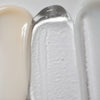 Eine Nahaufnahme zeigt die Texturen des Solawaves LightBoost Wand Activating Serum: cremiges Beige, transparentes Gel mit LightBoost-Technologie und glatte hellgraue/weiße Creme. Die Texturen reichen von cremig bis gelartig und weisen jeweils ein glänzendes Finish auf.